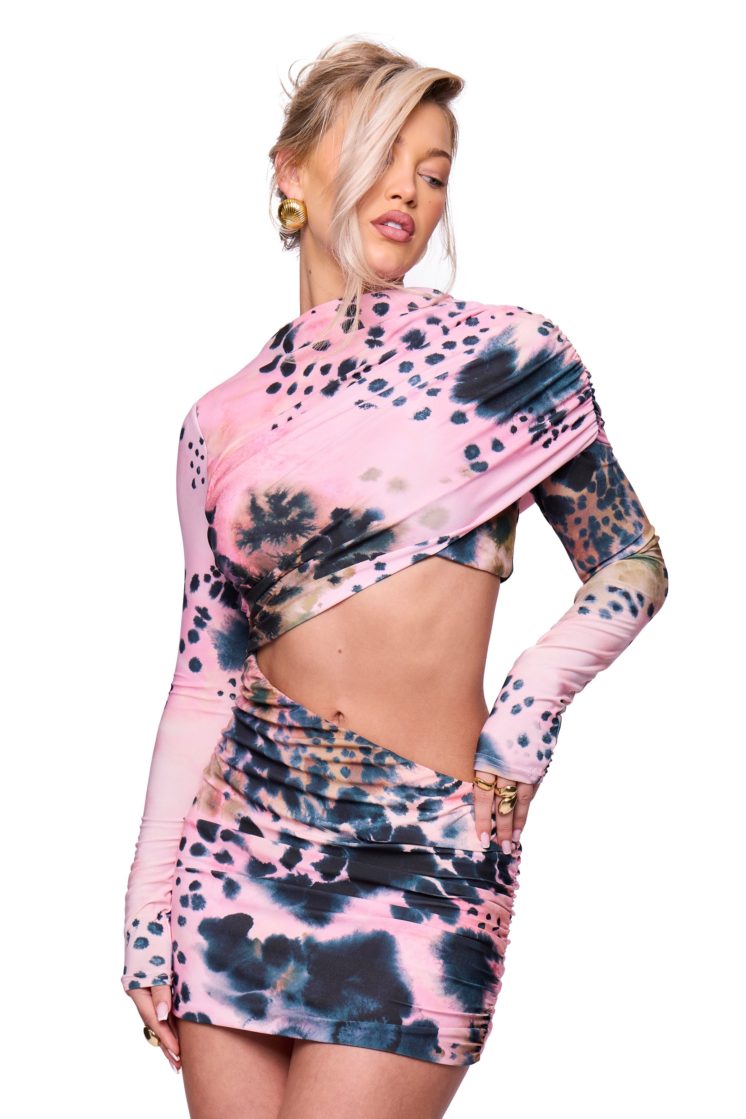 model wearing a tie-dye print dress in pink with cut-out design on a white background